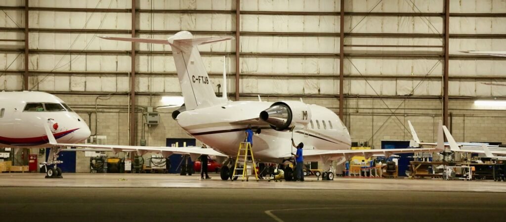 Business jets being prepared in a maintenance hangar